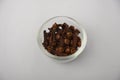 Aromatic cloves on white glass bowl with white background.