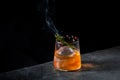 aromatic cocktail with a sprig of pine needles and round ice on a dark background, side view Royalty Free Stock Photo