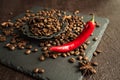 Aromatic coffee beans in a metal Turkish bowl, anise with bitter hot chili pepper on a black background 1 Royalty Free Stock Photo