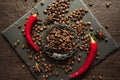 Aromatic coffee beans in a metal Turkish bowl, anise with bitter hot chili pepper on a black background Royalty Free Stock Photo