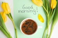 Aromatic coffee, beautiful flowers and card with words GOOD MORNING on white table Royalty Free Stock Photo