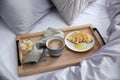 Aromatic coffee, biscuit and beautiful flower on bed with grey linens indoors Royalty Free Stock Photo