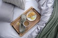 Aromatic coffee, biscuit and beautiful flower on bed with grey linens indoors, top view Royalty Free Stock Photo