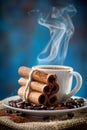 Aromatic coffee cup with steaming cinnamon and roasted coffee beans for a fragrant experience