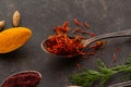 Aromatic condiment saffron in a spoon on dark background