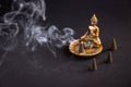 Aromatic cone on beautiful buddha holder burning and creating smoke Royalty Free Stock Photo