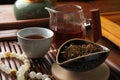 Aromatic Dianhong tea and prayer beads on wooden tray, closeup. Traditional ceremony