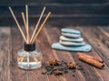 Aromatic freshener with reed sticks is on the brown wooden table. Close up