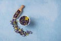 Aromatic herbal dry tea lavender and chamomile loose near white cup on blue wood table Royalty Free Stock Photo