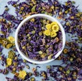 Aromatic herbal dry tea lavender and chamomile loose near white cup on blue wood table macro Royalty Free Stock Photo