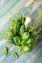 Aromatic herbs in mortar bowl on rustic wooden table top view. Basil, thyme, rosemary and tarragon. Fresh ingredients for cooking. Royalty Free Stock Photo