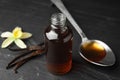 Aromatic homemade vanilla extract on table, closeup