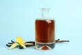 Aromatic homemade vanilla extract on blue background