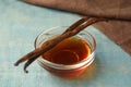 Aromatic homemade vanilla extract on light wooden table, closeup