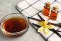 Aromatic homemade vanilla extract on light grey table