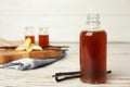 Aromatic homemade vanilla extract on wooden table. Space for text Royalty Free Stock Photo