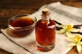 Aromatic homemade vanilla extract on table