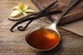 Aromatic homemade vanilla extract on table, closeup