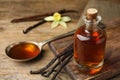 Aromatic homemade vanilla extract on wooden table. Space for text