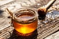 Aromatic honey into jar on wooden table. bee products by organic natural ingredients concept, closeup