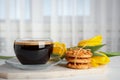 Aromatic morning coffee, cookies and flowers on white table