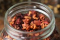 Aromatic fruit tea with hibiscus petals, fruit slices and berries. Closeup of dry organic fruit tea in an open glass jar