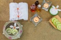 Aromatic oil, burned candle, pink flowers, sliced lime, white towel on vintage grunge stone background