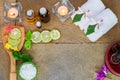 Aromatic oil, burned candle, pink yellow, orange flowers, green leaves, sliced lime, white towel on vintage stone background