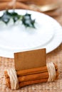 Aromatic place card with holly twig in white plate Royalty Free Stock Photo