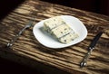 Aromatic and pungent. Piece of cheese on plate. Blue cheese food. Roquefort cheese. Gorgonzola cheese. Italian or danish