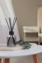 Aromatic reed air freshener and eucalyptus branch on white table in room Royalty Free Stock Photo