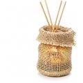 Aromatic reed diffuser in a burlap-wrapped glass bottle, isolated on a white background Royalty Free Stock Photo