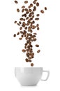 Aromatic roasted coffee beans falling into cup on white background Royalty Free Stock Photo