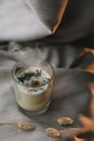 aromatic scented candle with smoke on beige textile background.