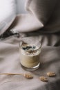 aromatic scented candle with smoke and dried flowers on beige textile background.
