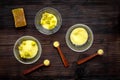 Aromatic spa salt. Yellow spa salt with delicate spring flowers on dark wooden background top view