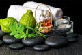 Aromatic spa still life of bottles essential oil, fresh mint, rosemary, bergamot fruits, towels and candles on zen stones Royalty Free Stock Photo