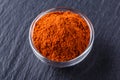 Aromatic spicy chilli powder on a dark stone background