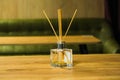 aromatic sticks in a square bottle on the table against the background of a green sofa in the office center Royalty Free Stock Photo