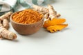 Aromatic turmeric powder and raw roots on white table. Space for text Royalty Free Stock Photo