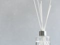 Aromatizer. Aromatic air freshener in a transparent glass bottle with white reeds on a gray background Royalty Free Stock Photo