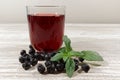 Aronia Berry Juice and mint on wooden table Royalty Free Stock Photo