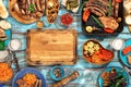 Around wooden cutting board different food grilled on wooden tab