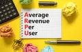 ARPU average revenue per user symbol. Concept words ARPU average revenue per user on white note on beautiful yellow background.