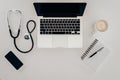 Arranged stethoscope, laptop, notebook and cup of coffee at doctors workplace Royalty Free Stock Photo