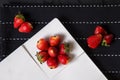 Arranged strawberries in plate on table with scattered berries Royalty Free Stock Photo