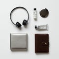 Arranged on a white surface are various items: black wireless headphones, a bottle of Royalty Free Stock Photo