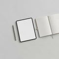 Arrangement of a blank digital tablet an open lined notebook and a Royalty Free Stock Photo