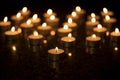 Arrangement of burning tea lights on a black background. 2 Royalty Free Stock Photo