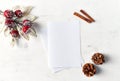 An arrangement of Christmas decorations and blank paper cards on white wooden background. Flatlay. Copy space